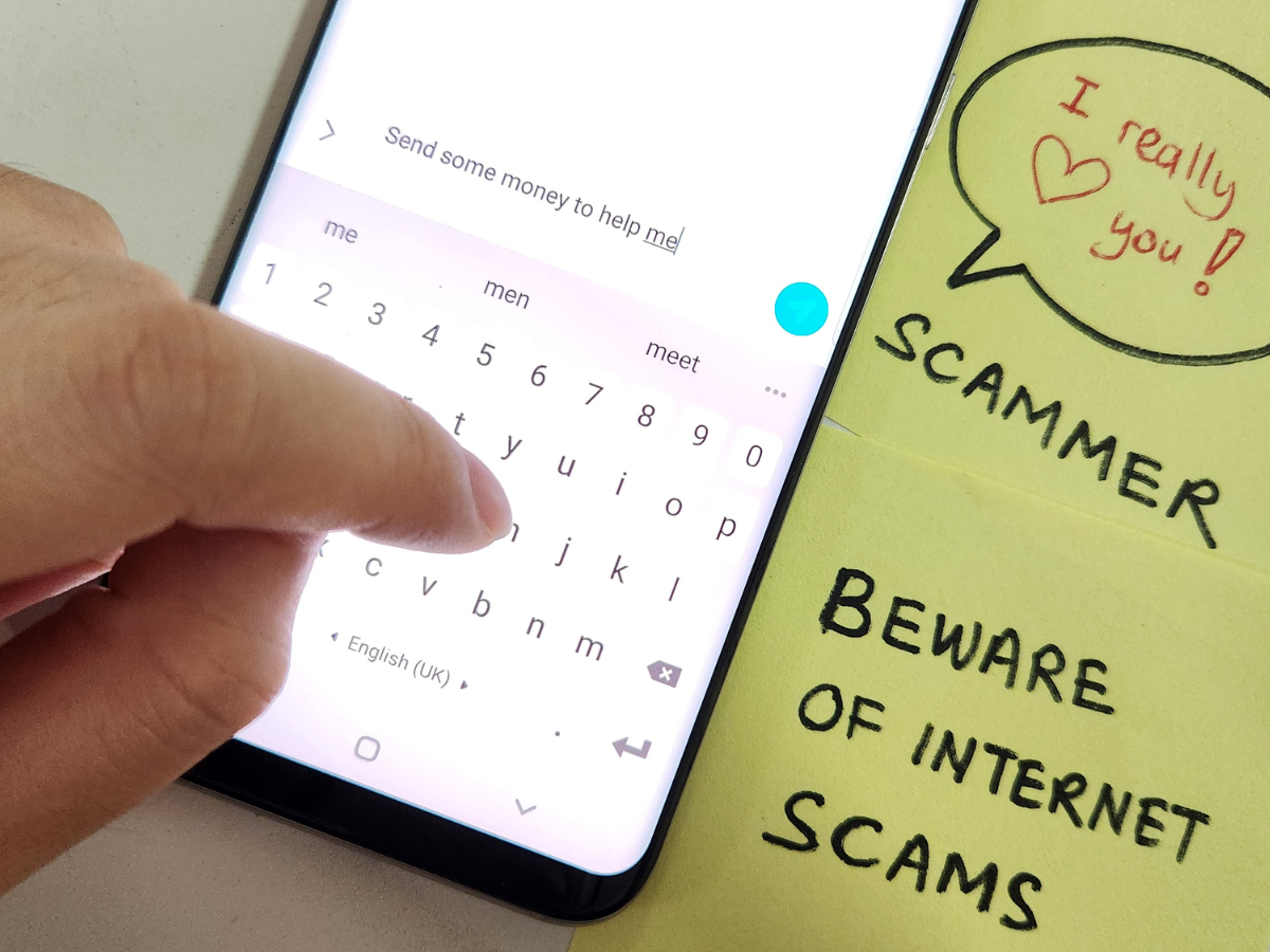 Picture of cellphone with the words scammer, beware of internet scams.
