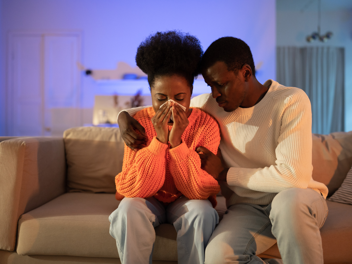 Black couple, the woman is crying, and the man is comforting her